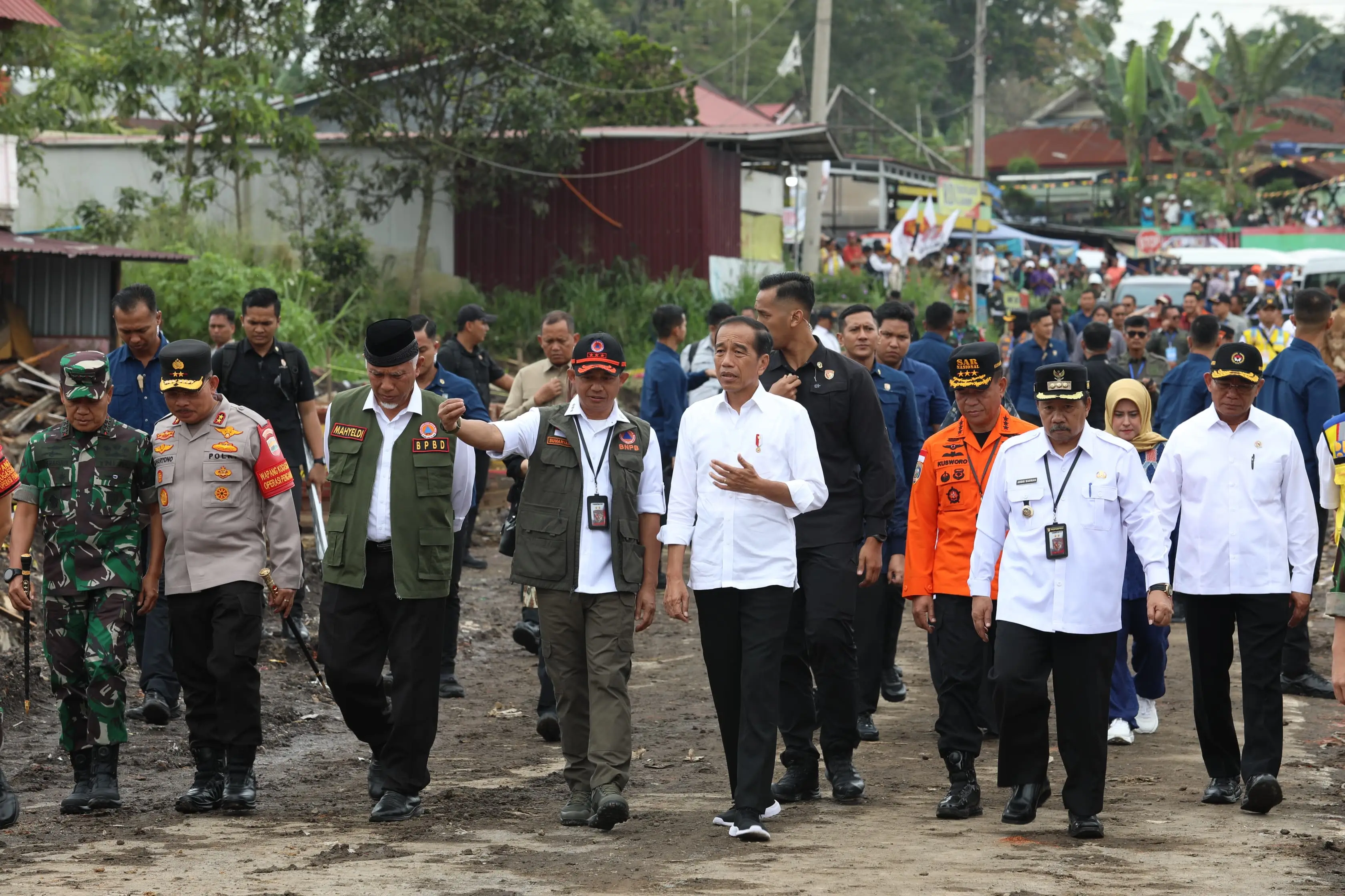 Kepala BNPB Letjen TNI Suharyanto, S.Sos., M.M., (rompi hijau dengan topi hitam) memberikan informasi terkini kepada Presiden Ir. Joko Widodo saat meninjau lokasi terdampak banjir lahar hujan Gunungapi Marapi di Nagari Bukit Batabuah, Kabupaten Agam, Sumatera Barat pada Selasa (21/5).